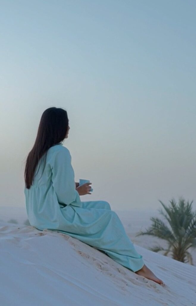 Image of AI generated lady sitting on sand